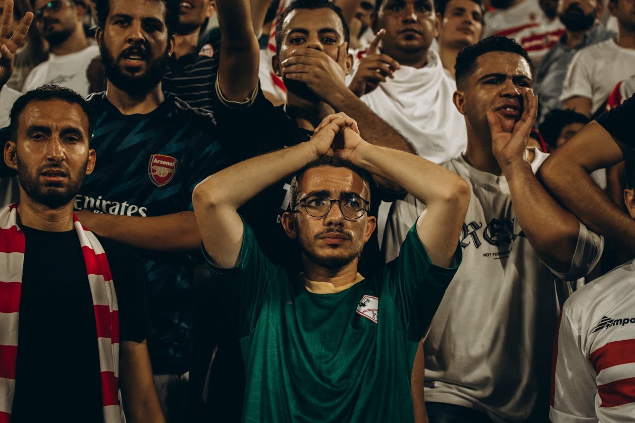 Energetic crowd of football fans showing emotions during a live match.